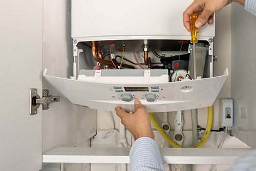 HVAC technician repairing an indoor boiler in Peoria