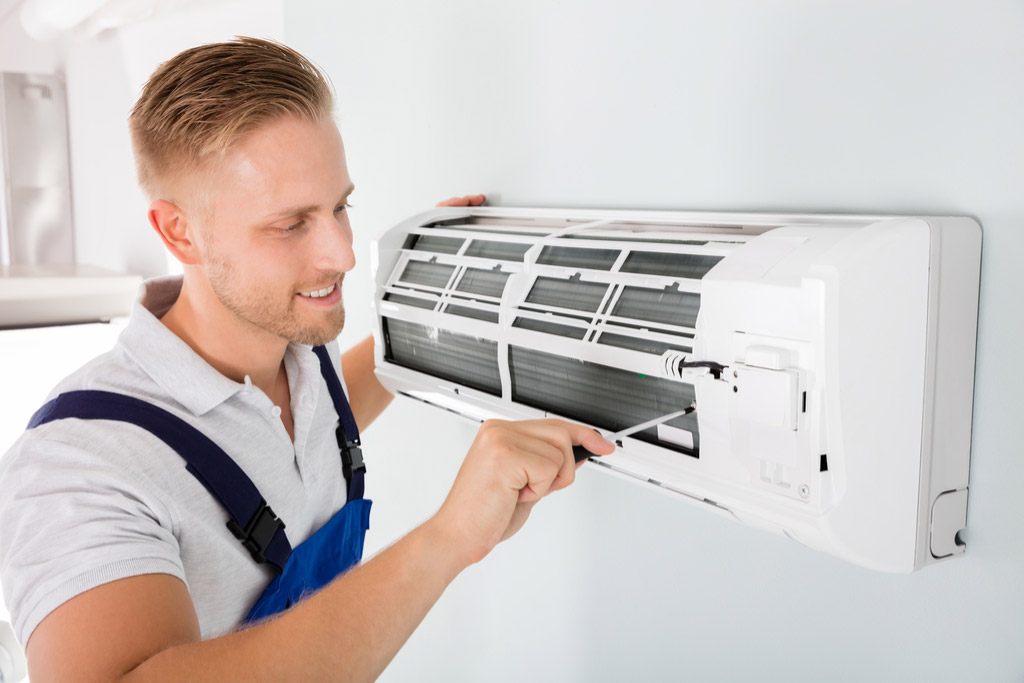 HVAC technician performing ductless air conditioning maintenance in Peoria