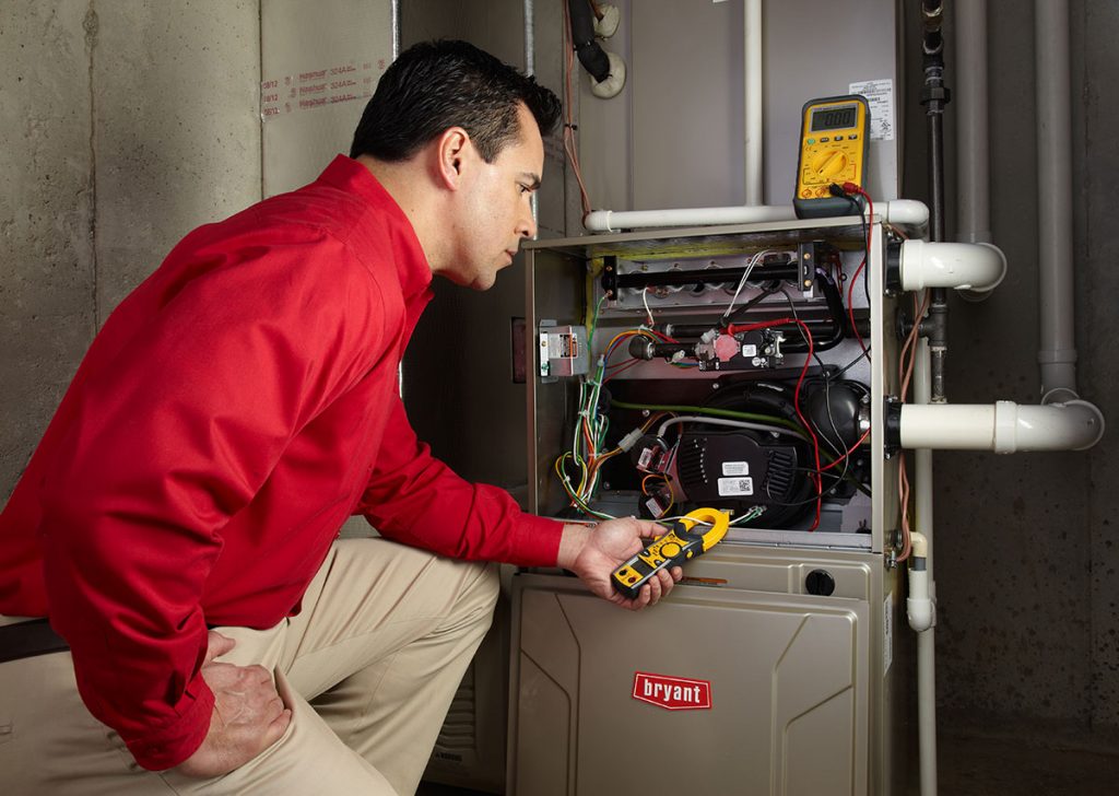 HVAC technician repairing an indoor furnace in Peoria