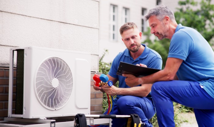 HVAC technicians installing an outdoor air conditioning unit in Peoria