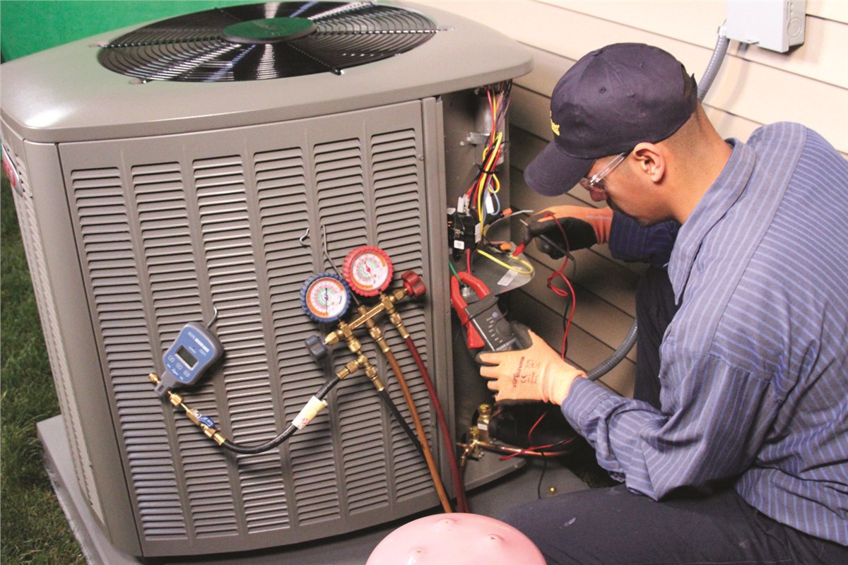 HVAC technician testing an outdoor air conditioning unit in Peoria
