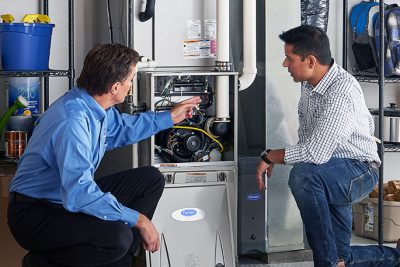 65df8c11f3e4c468cbd351a5_furnace repair vs replacement – Copy HVAC technician explaining furnace repair and maintenance to a homeowner in Peoria, AZ
