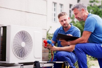 ac-installation-in-claremont-ca HVAC technicians reviewing an outdoor air conditioning unit in Peoria, AZ