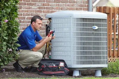 design-air-heating-and-air-conditioning-decatur-il-05 – Copy HVAC technician inspecting an outdoor air conditioning unit in Peoria, AZ
