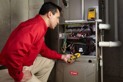 furnace repair Heating and air conditioning technician servicing an indoor furnace in Peoria, AZ